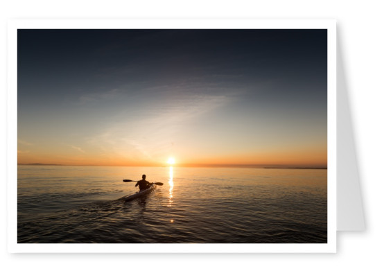Kajak paddling towards the horizon