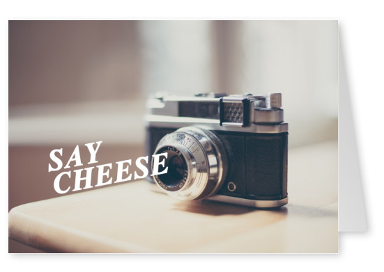 kamera auf einem tisch und spruch say cheese