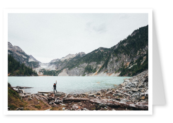 Junge an einem See mit Bergen im Hitnergrund