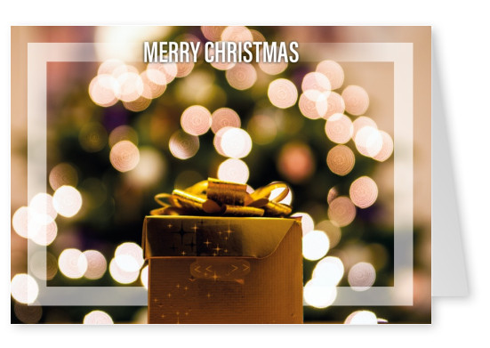 Weihnachtsgrußkarte mit Geschenk im Fokus und Lichtern im Hintergrund
