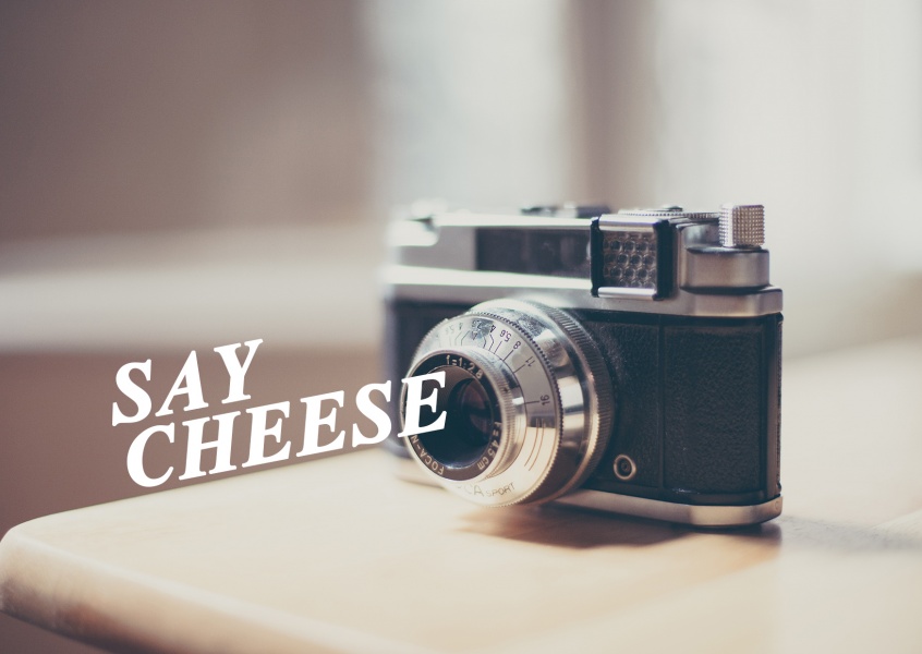 kamera auf einem tisch und spruch say cheese
