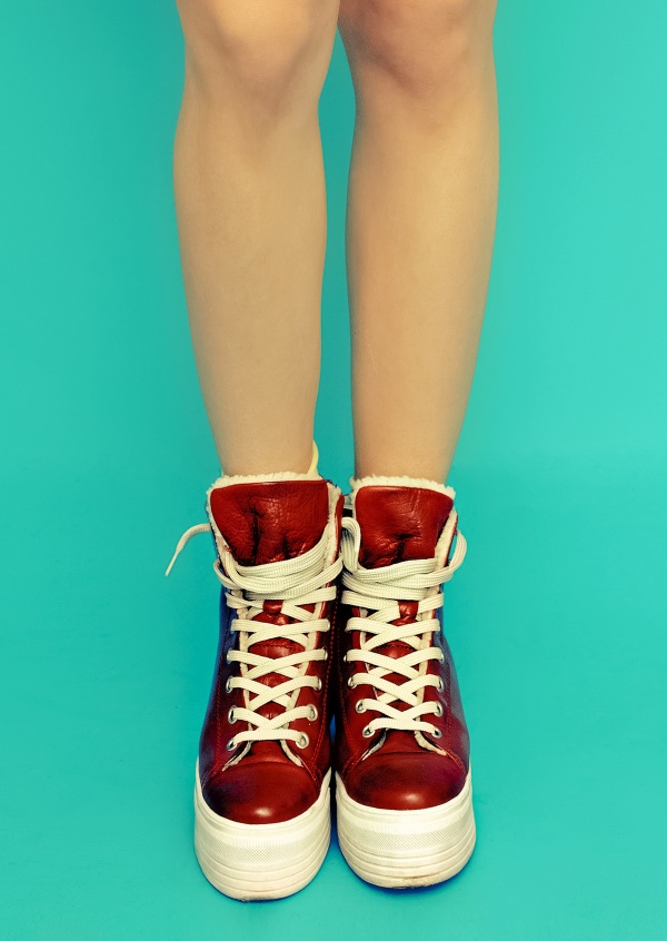 Kubistika rote Sneaker mit Frauenbeinen