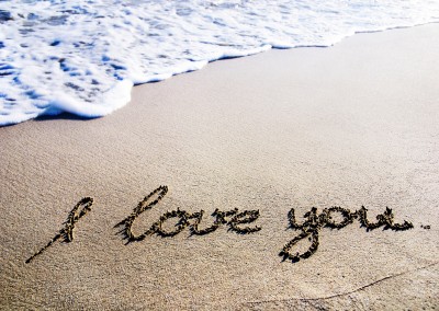 beach with waves and the message i love you written by hand in the sand