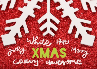 Weihnachtsgrußkarte XMAS mit großer Schneeflocke auf rotem glitzernen Grund